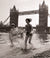 Children paddling on the foreshore below Tower Bridge by Mirrorpix. Unframed art print.